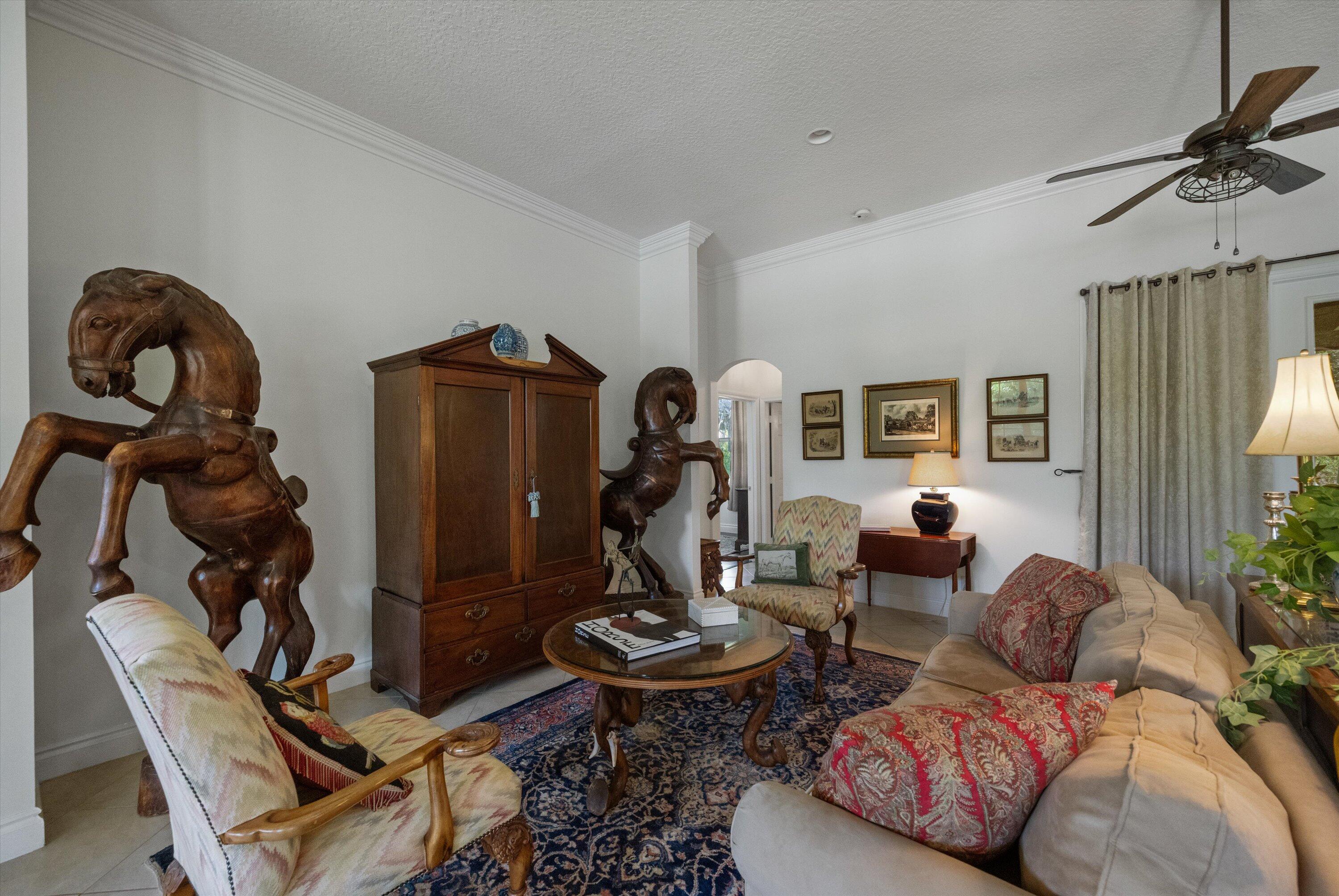 19986 Black Falcon Road Loxahatchee, FL 33470 - Photo 20 of 105 a living room with furniture a rug and a chandelier