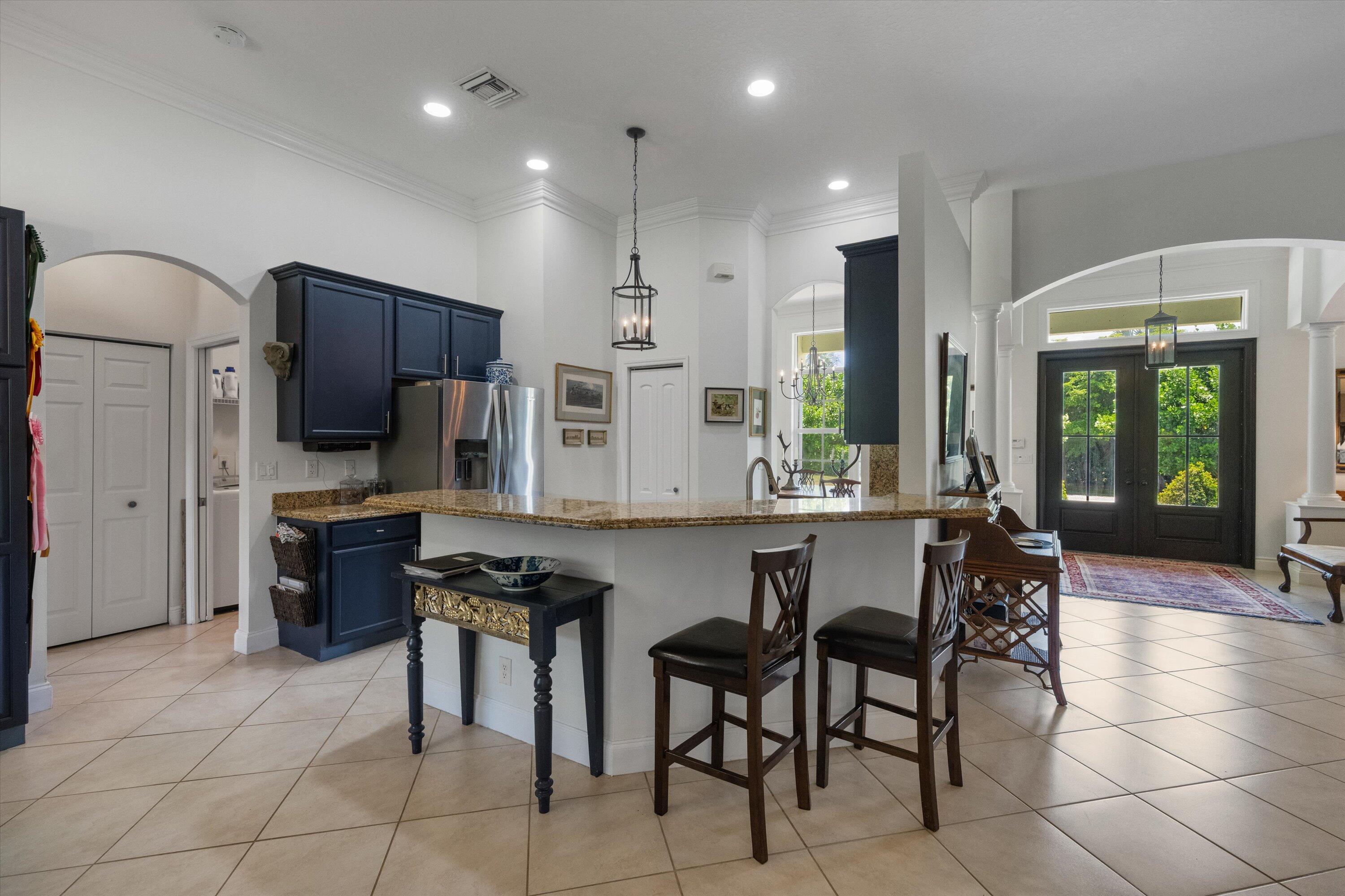 19986 Black Falcon Road Loxahatchee, FL 33470 - Photo 27 of 105 a kitchen with stainless steel appliances granite countertop a stove a sink a refrigerator and a microwave