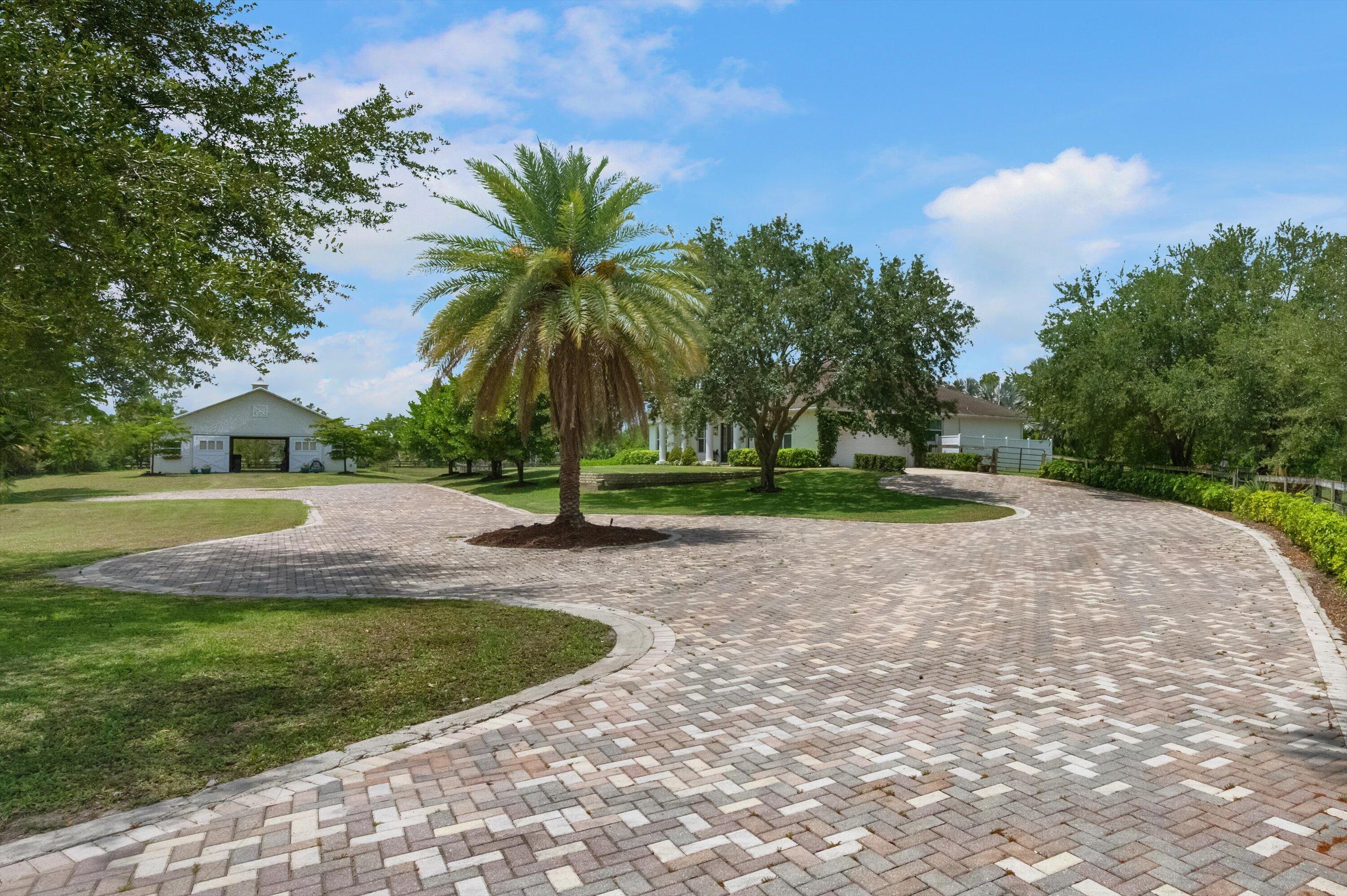 19986 Black Falcon Road Loxahatchee, FL 33470 - Photo 3 of 105 a view of a garden with palm trees