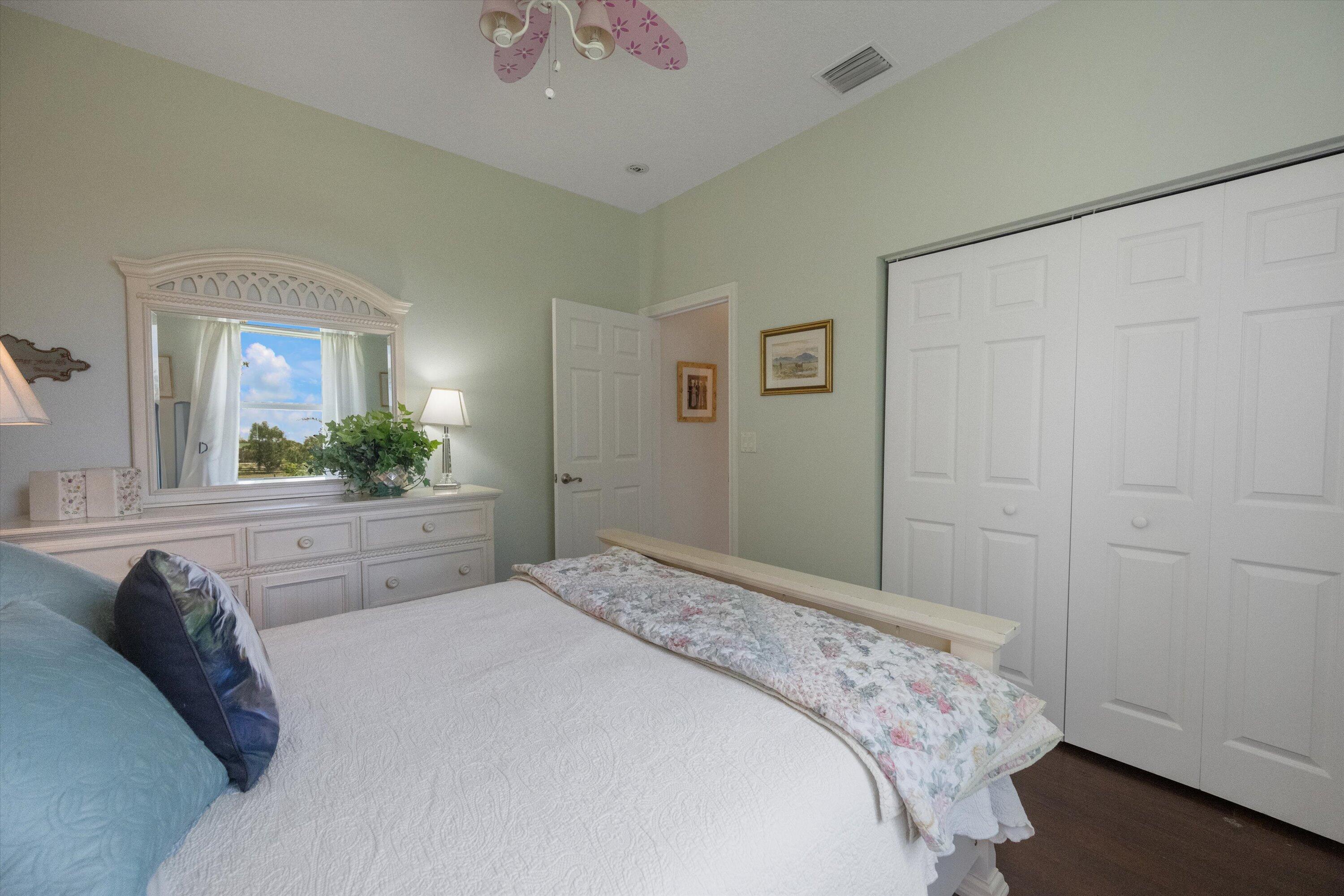 19986 Black Falcon Road Loxahatchee, FL 33470 - Photo 35 of 105 a spacious bedroom with a bed and a mirror