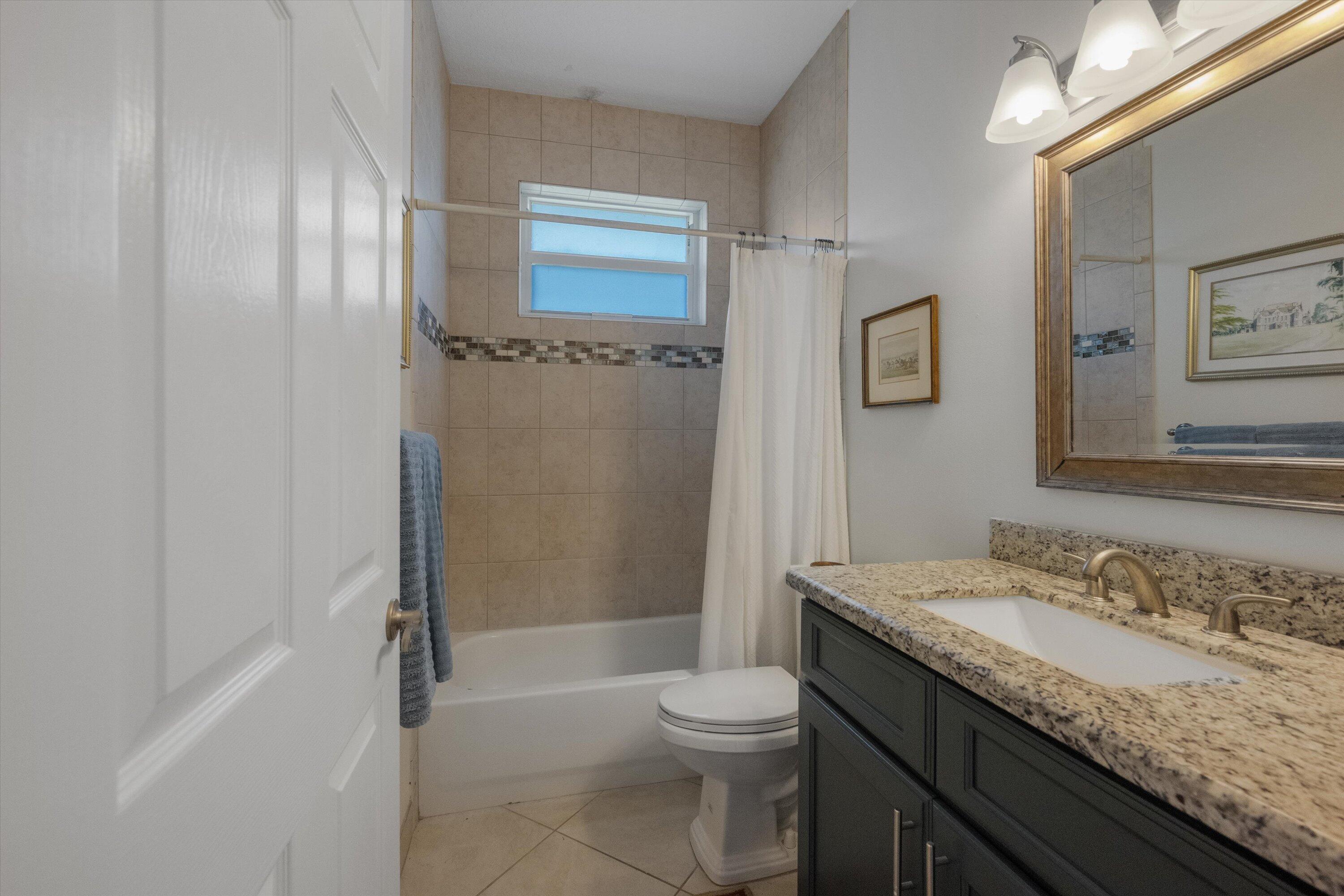 19986 Black Falcon Road Loxahatchee, FL 33470 - Photo 36 of 105 a bathroom with a granite countertop sink toilet and shower