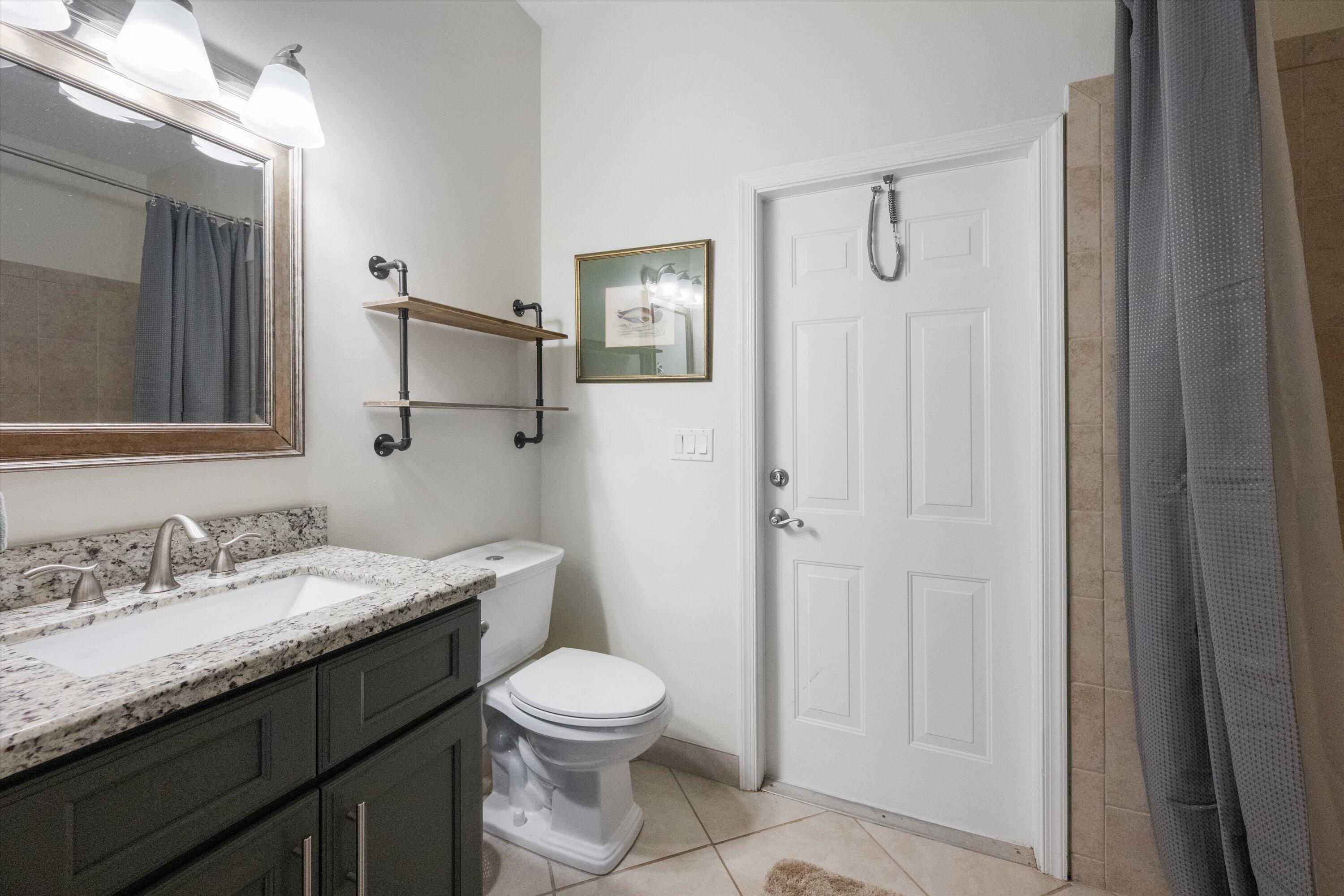 19986 Black Falcon Road Loxahatchee, FL 33470 - Photo 38 of 105 a bathroom with a granite countertop sink toilet and shower
