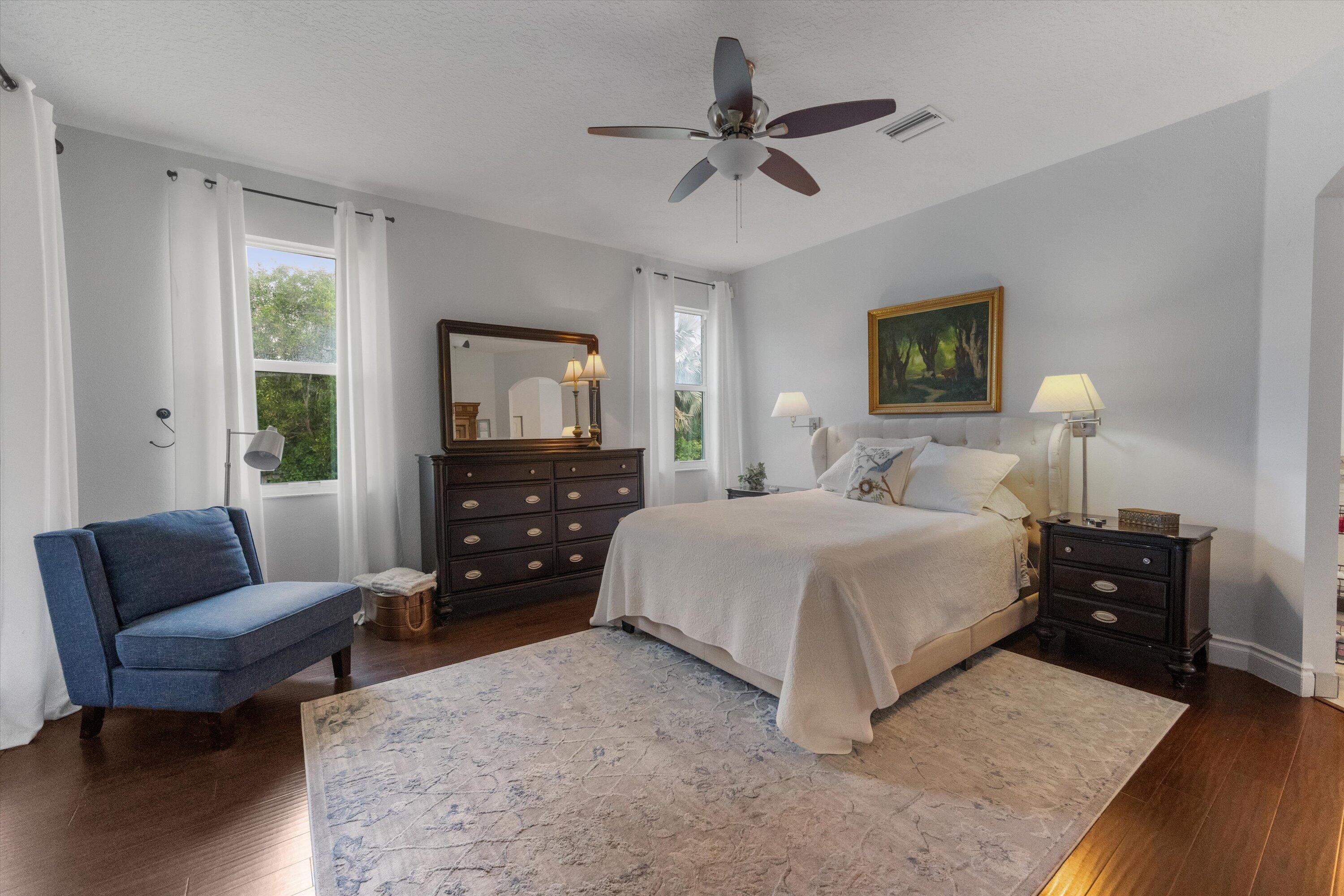 19986 Black Falcon Road Loxahatchee, FL 33470 - Photo 39 of 105 a bedroom with a bed a couch and a flat tv screen on dresser