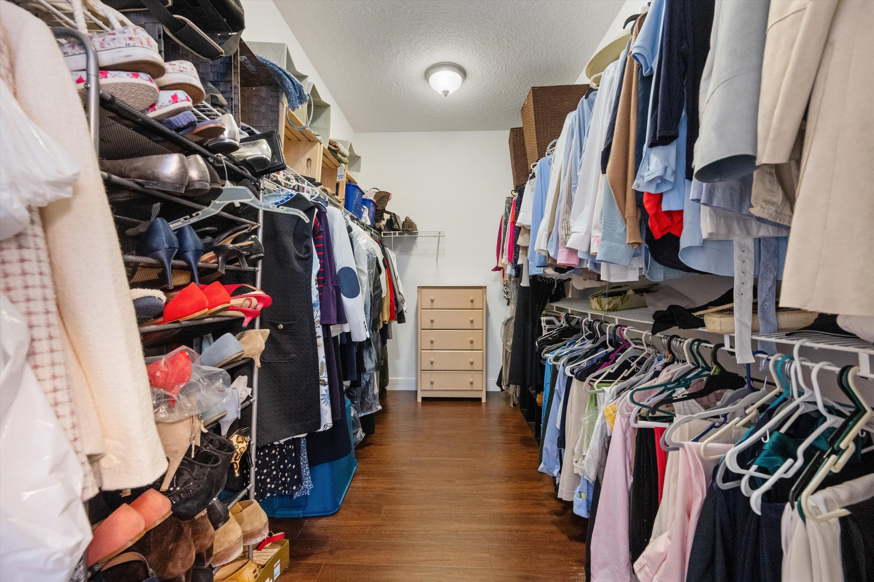 19986 Black Falcon Road Loxahatchee, FL 33470 - Photo 48 of 105 a view of walk in closet with clothes