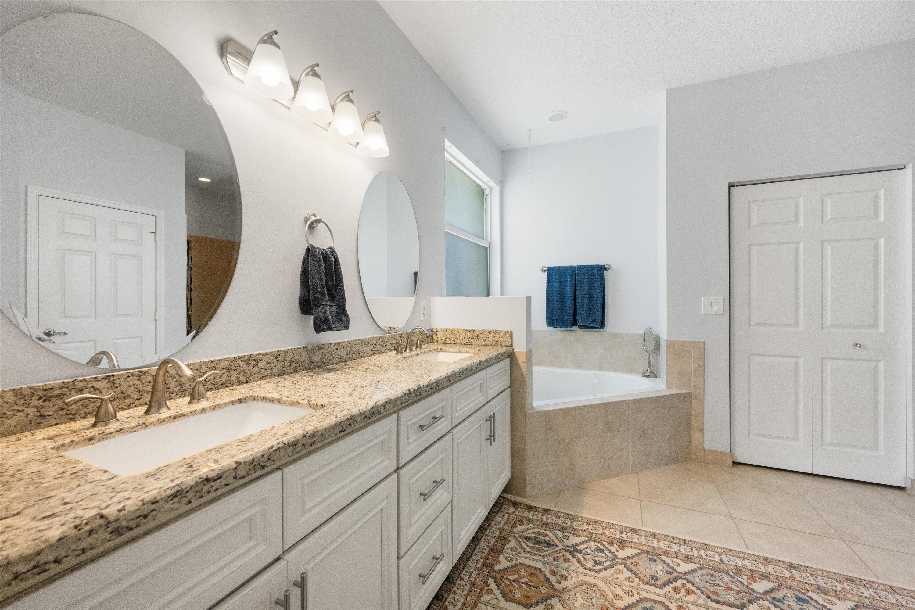 19986 Black Falcon Road Loxahatchee, FL 33470 - Photo 49 of 105 a bathroom with a granite countertop double vanity sink and mirror
