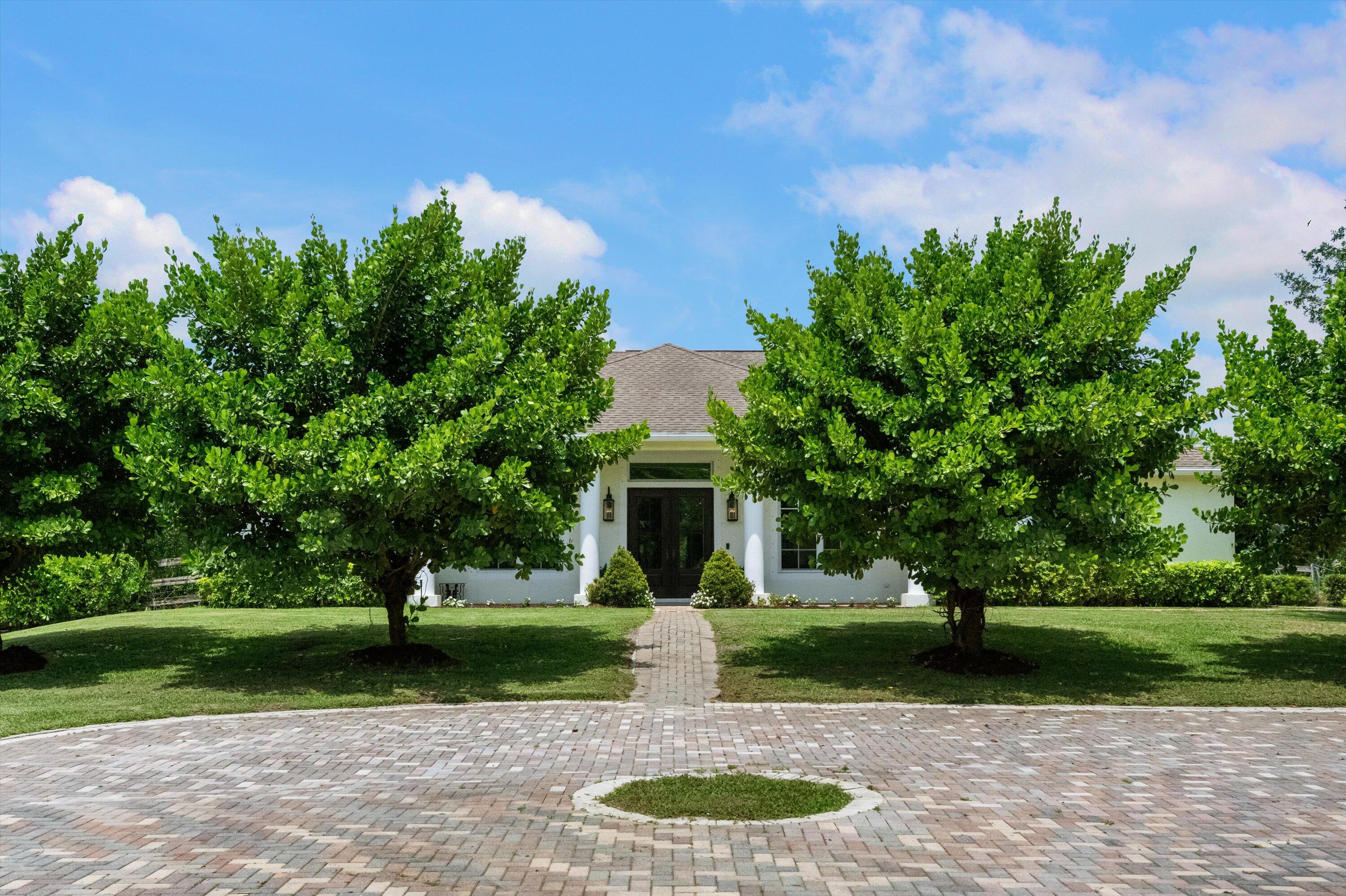 19986 Black Falcon Road Loxahatchee, FL 33470 - Photo 6 of 105 a front view of a house with garden