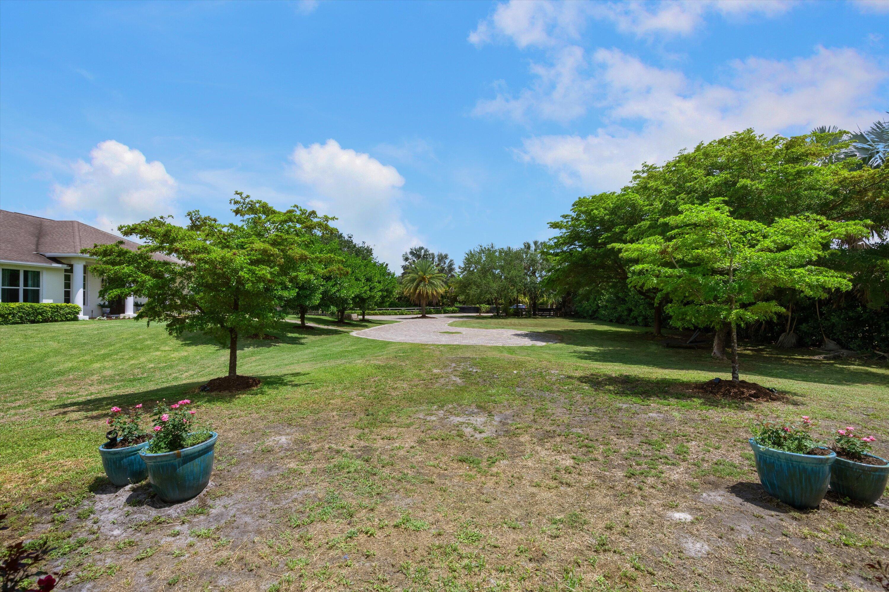 19986 Black Falcon Road Loxahatchee, FL 33470 - Photo 72 of 105 a backyard of a house with table and chairs