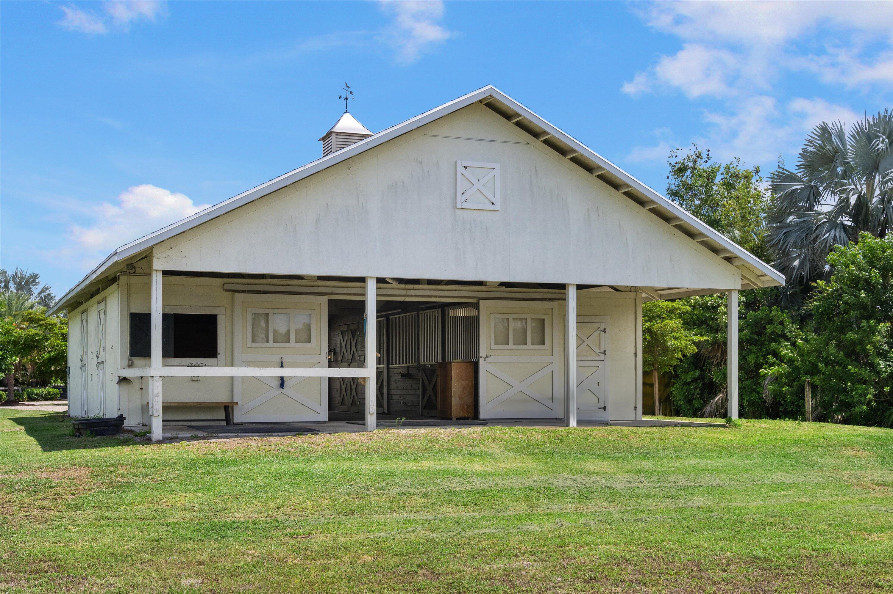 19986 Black Falcon Road Loxahatchee, FL 33470 - Photo 76 of 105 a front view of house with yard and green space