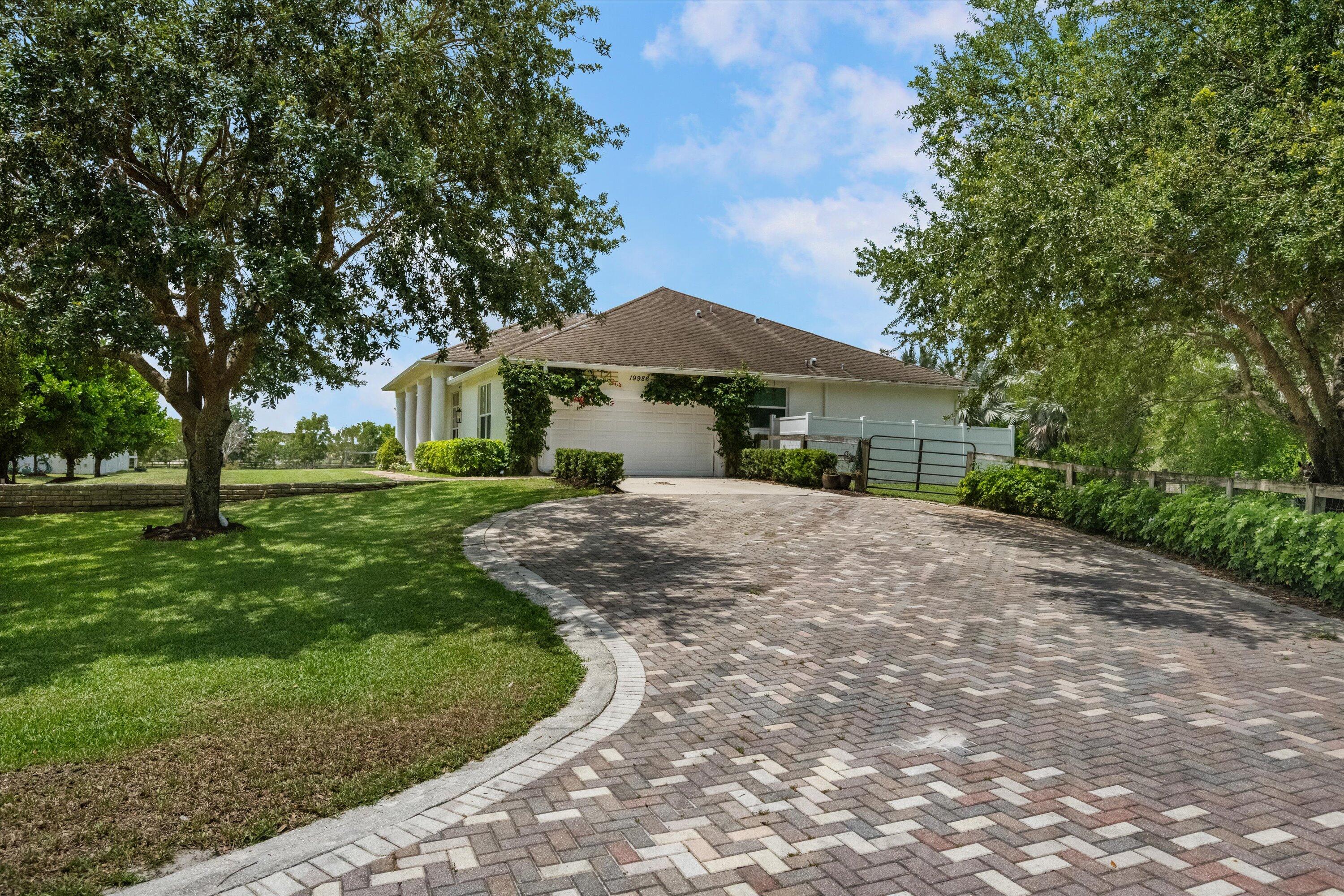 19986 Black Falcon Road Loxahatchee, FL 33470 - Photo 9 of 105 a front view of a house with a yard