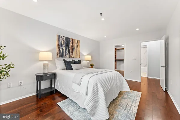 a spacious bedroom with a bed and a lamp