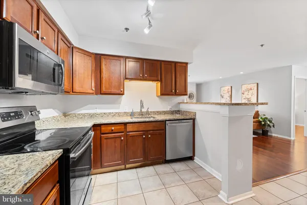 a kitchen with stainless steel appliances granite countertop a stove sink and cabinets
