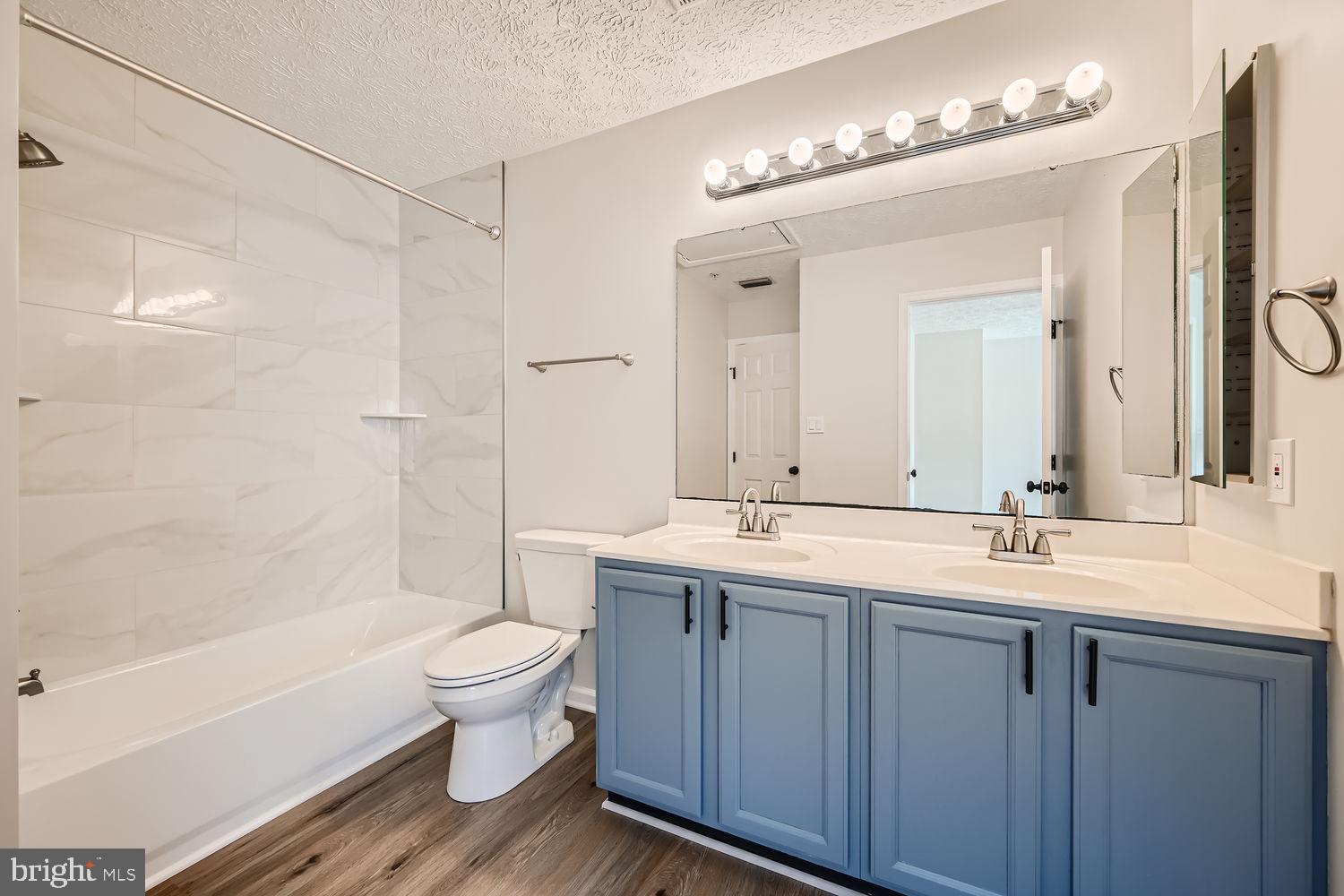 8540 Pine Meadows Drive Odenton, MD 21113 - Photo 18 of 29 a bathroom with a double vanity sink toilet mirror and bathtub
