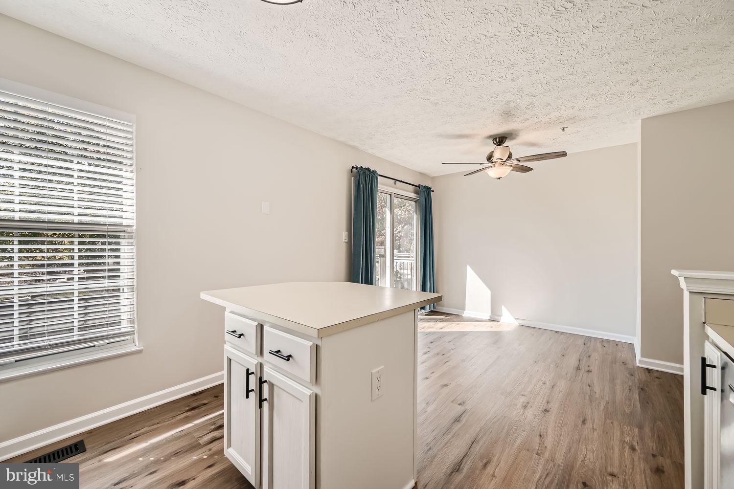 8540 Pine Meadows Drive Odenton, MD 21113 - Photo 10 of 29 a view of a kitchen and an empty room with wooden floor