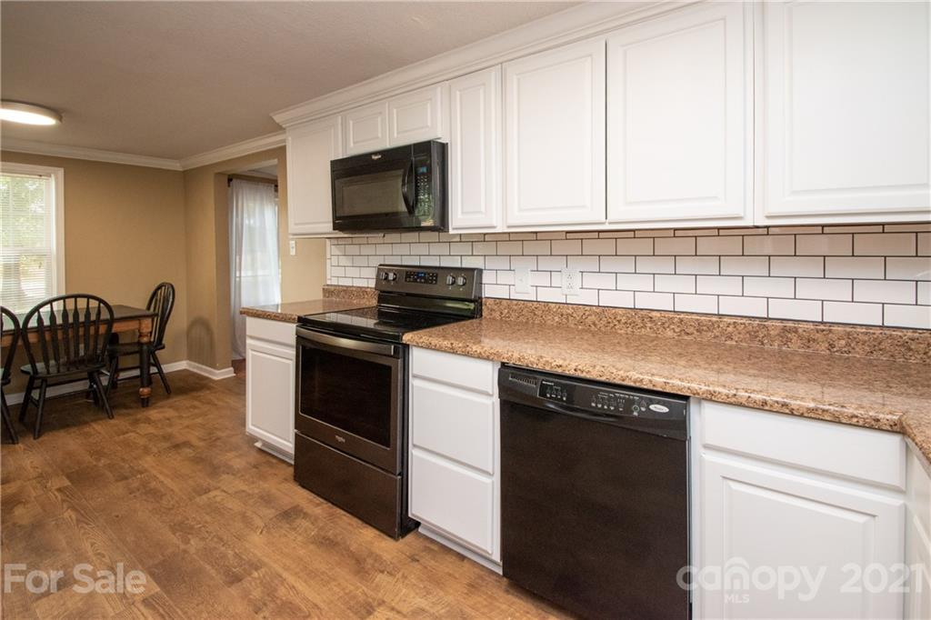 2612 Long Hope Road Monroe, NC 28112 - Photo 14 of 32 a kitchen with granite countertop a stove a sink and a microwave