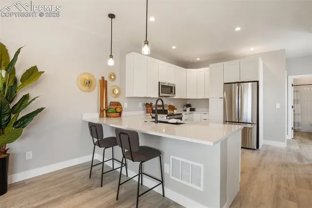 a kitchen with a sink a refrigerator a stove a dining table and chairs