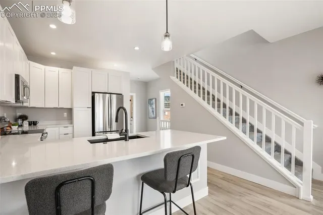 a kitchen with furniture a refrigerator and a view of living room
