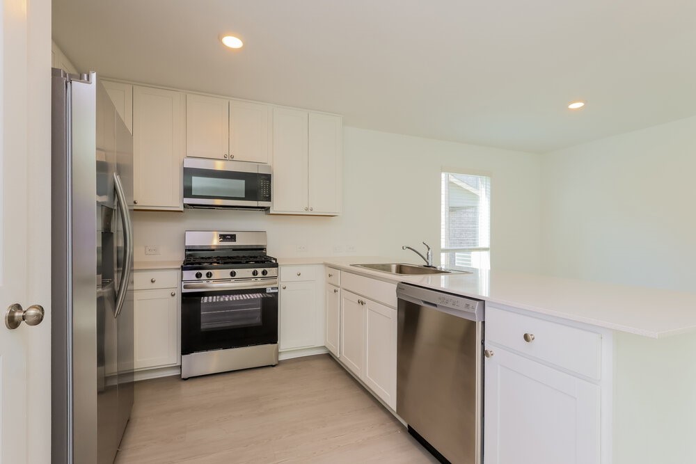 2612 Shady Cedar Court Conroe, TX 77301 - Photo 8 of 17 a kitchen with stainless steel appliances granite countertop a stove a sink and a refrigerator
