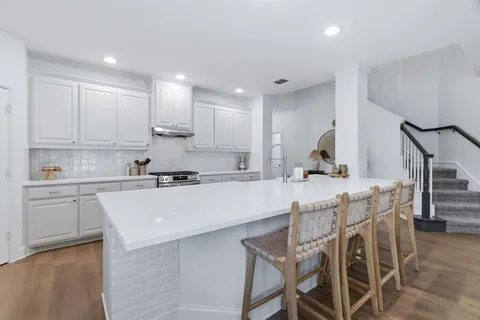 a large kitchen with stainless steel appliances a large counter top and a stove