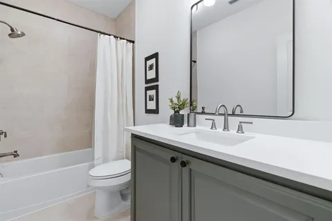 a bathroom with a granite countertop sink a toilet and shower