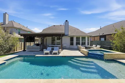 a view of a house with swimming pool and sitting area