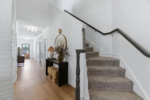 a living room with furniture kitchen view and a large window