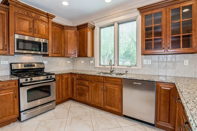 a kitchen with stainless steel appliances granite countertop a stove sink and microwave