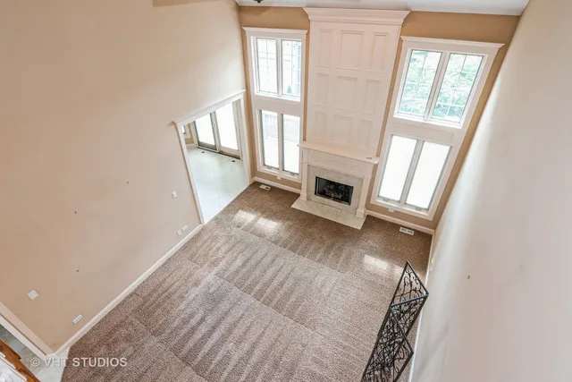 an empty room with wooden floor and a fireplace