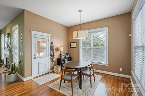 a kitchen with stainless steel appliances granite countertop a refrigerator a sink dishwasher a stove and white countertops with wooden floor