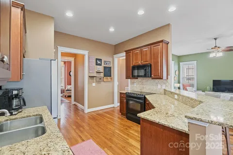 a kitchen with stainless steel appliances granite countertop a refrigerator and a stove top oven
