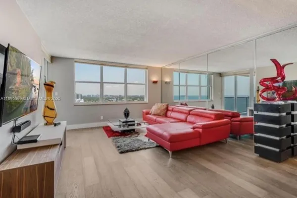 a living room with furniture a flat screen tv and a window