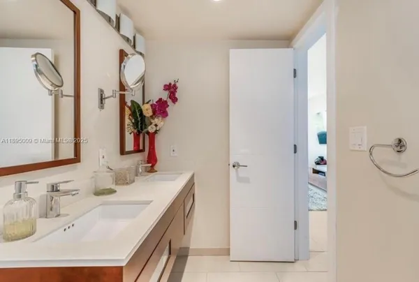 a bathroom with a granite countertop shower sink vanity and mirror