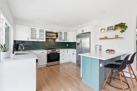 a kitchen with granite countertop white cabinets and white appliances