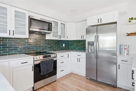 a kitchen with stainless steel appliances granite countertop a refrigerator a stove a sink and a microwave