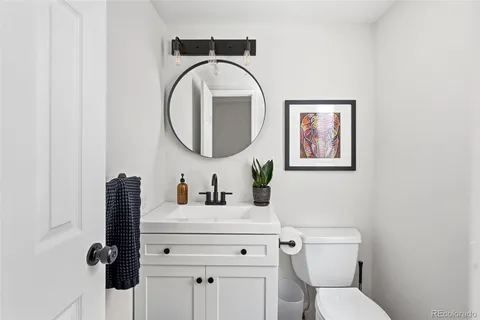a bathroom with a toilet sink vanity and mirror