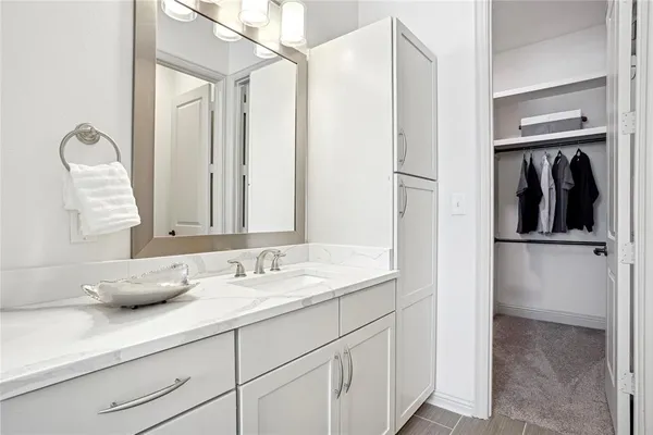 a en suite bathroom with a granite countertop sink and a mirror