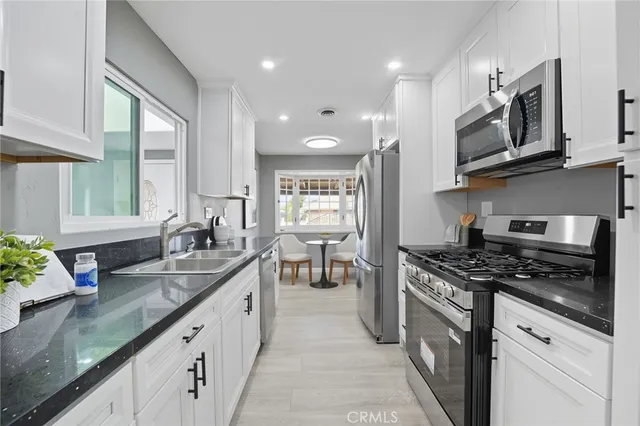 a kitchen with stainless steel appliances granite countertop a sink stove and cabinets