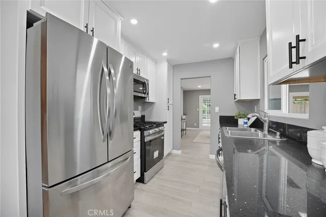 a kitchen with refrigerator a sink and cabinets