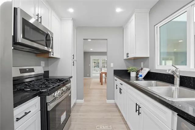 a kitchen with stainless steel appliances granite countertop a sink stove and microwave