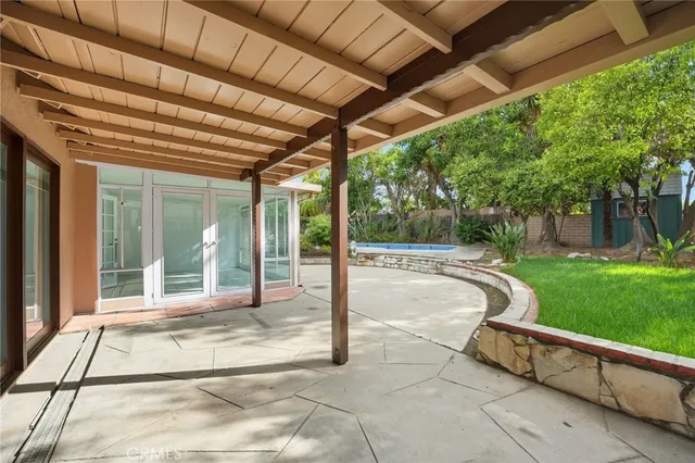 a backyard of a house with plants and large tree