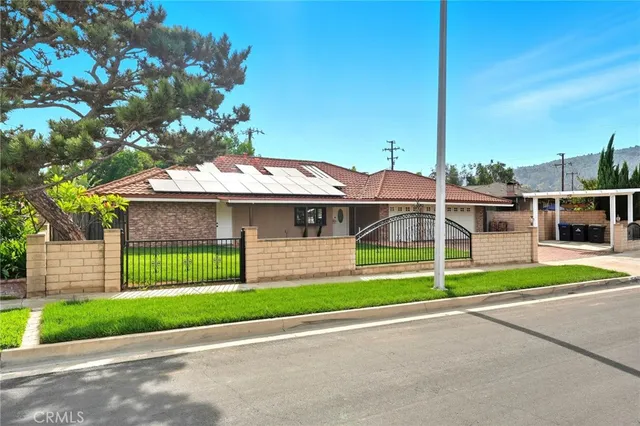 a front view of a house with a garden and yard