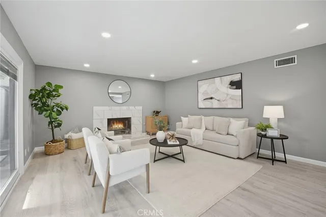 a living room with furniture a fireplace and a potted plant