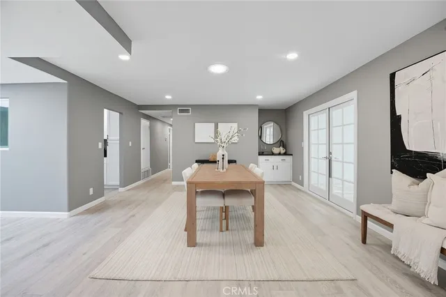 a living room with furniture a dining table and a large window