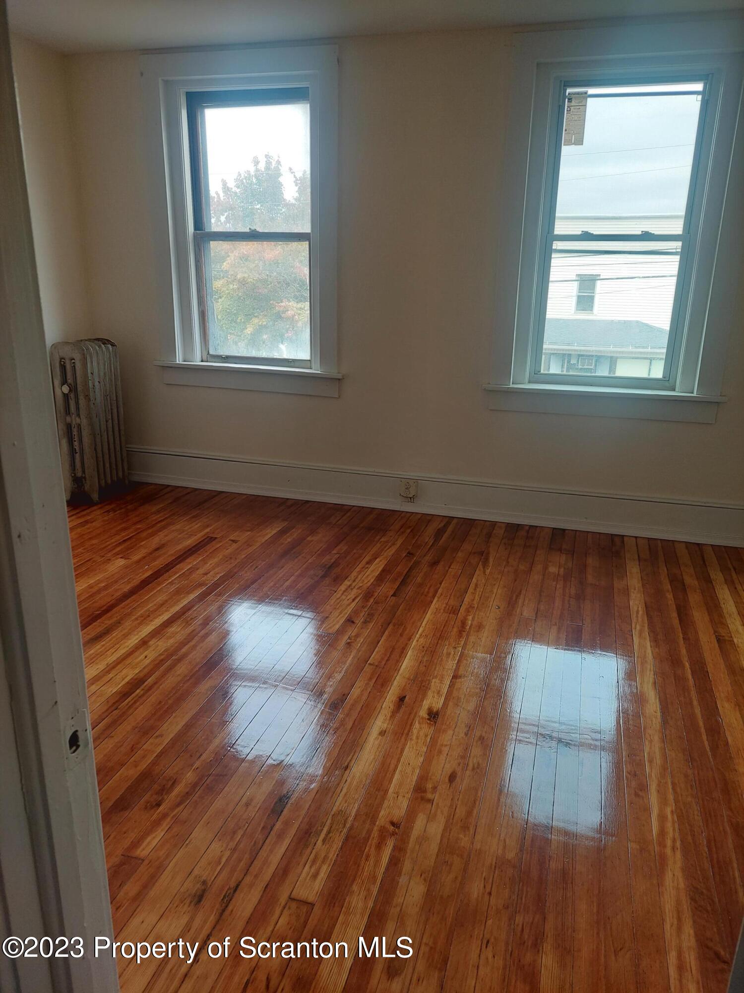 1703 Cedar Avenue Scranton, PA 18505 - Photo 2 of 14 an empty room with wooden floor and windows