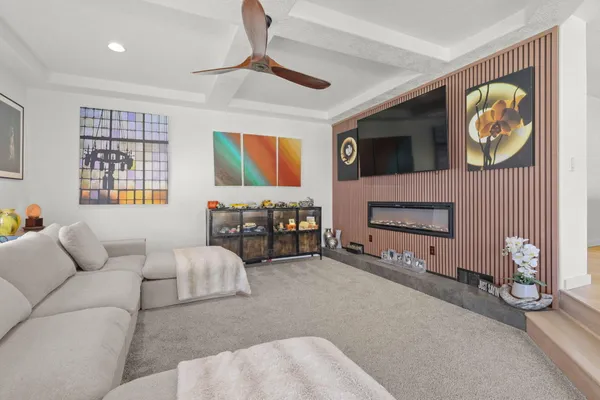 a living room with furniture a flat screen tv and a window