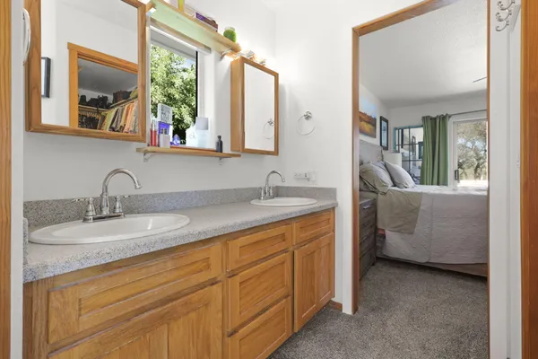 a en suite bathroom with a granite countertop sink and a mirror