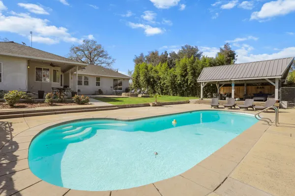 a view of a house with swimming pool and sitting area