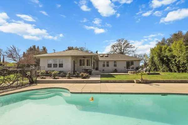 a front view of house with yard and swimming pool