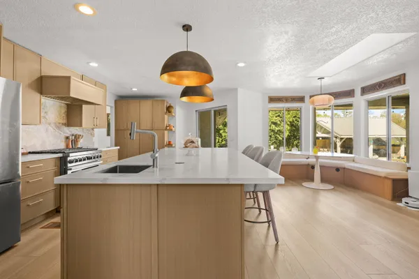 a kitchen with stainless steel appliances granite countertop a sink a stove and a refrigerator