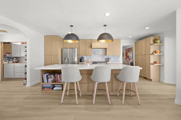 a kitchen with stainless steel appliances a dining table and chairs