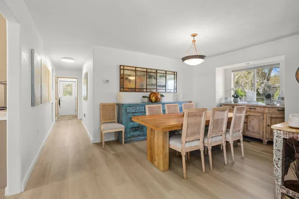 a dining room with furniture a chandelier and wooden floor